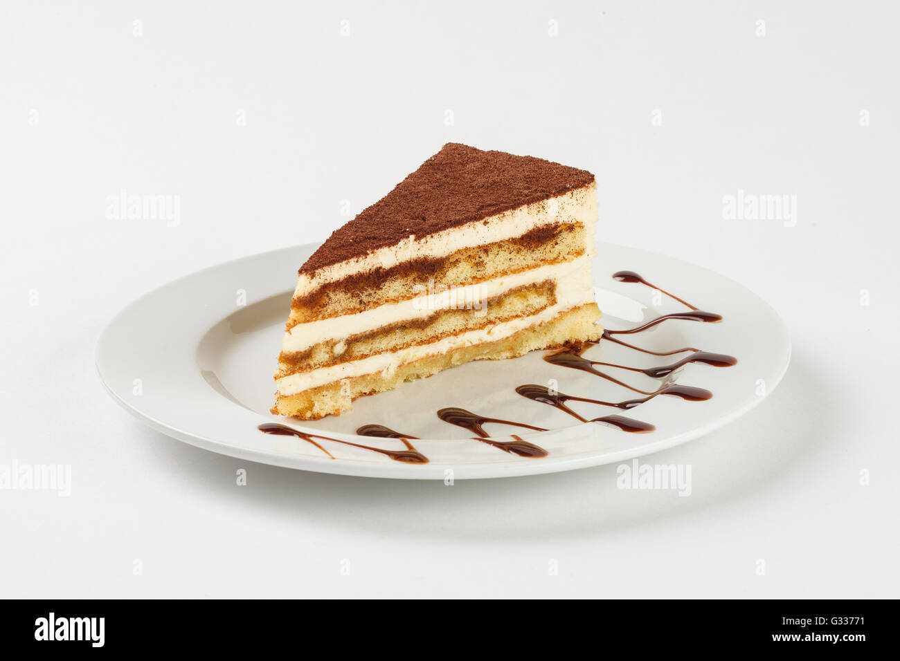 Delicious chocolate cream cake on the plate on white background. Close up side view. Stock Photo