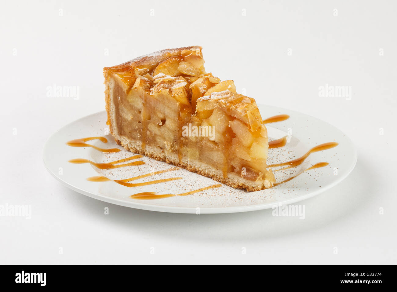 Delicious apple pie charlotte with caramel on the plate on white background. Close up side view. Stock Photo