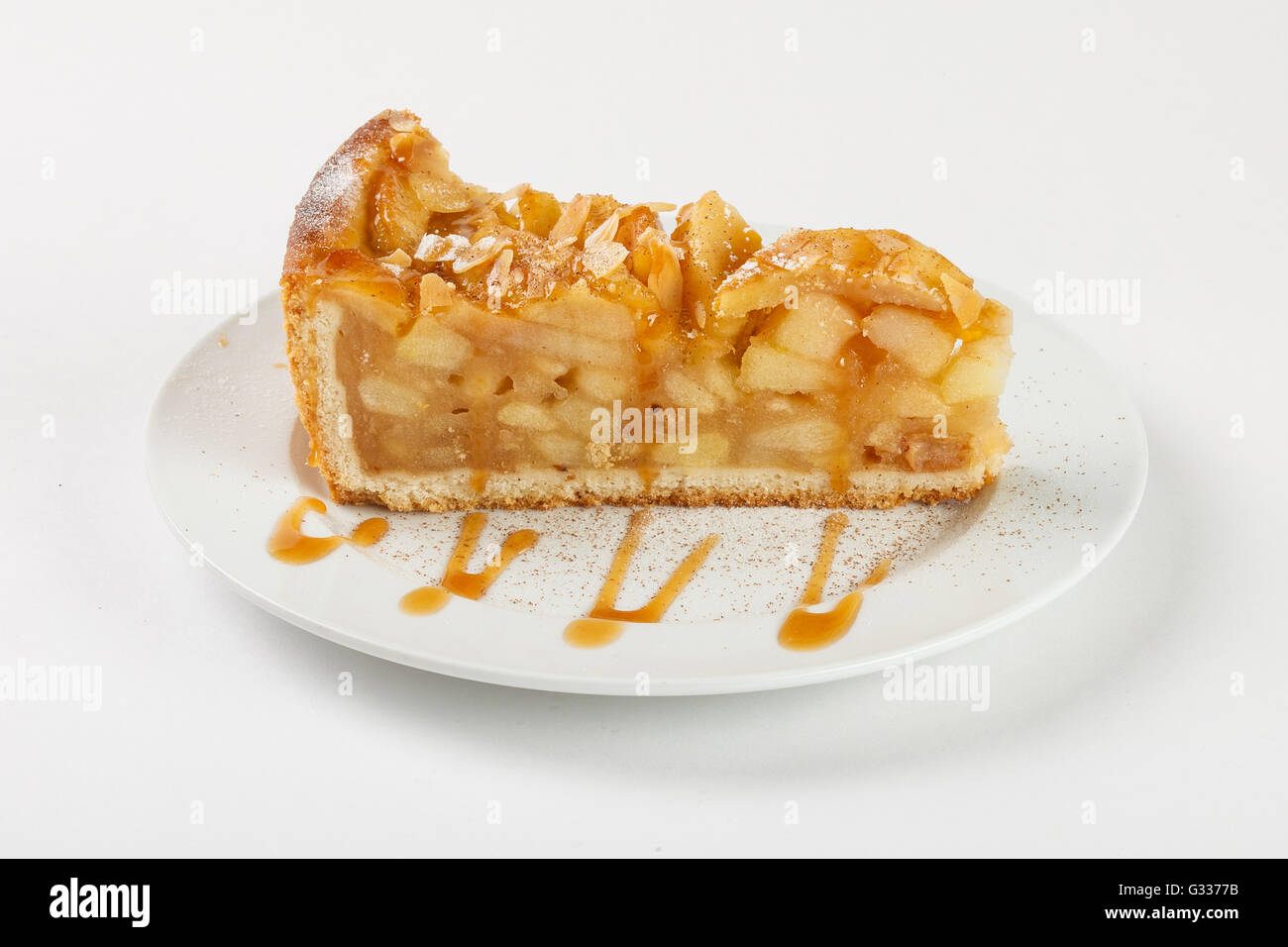 Delicious apple pie charlotte with caramel on the plate on white background. Close up side view. Stock Photo