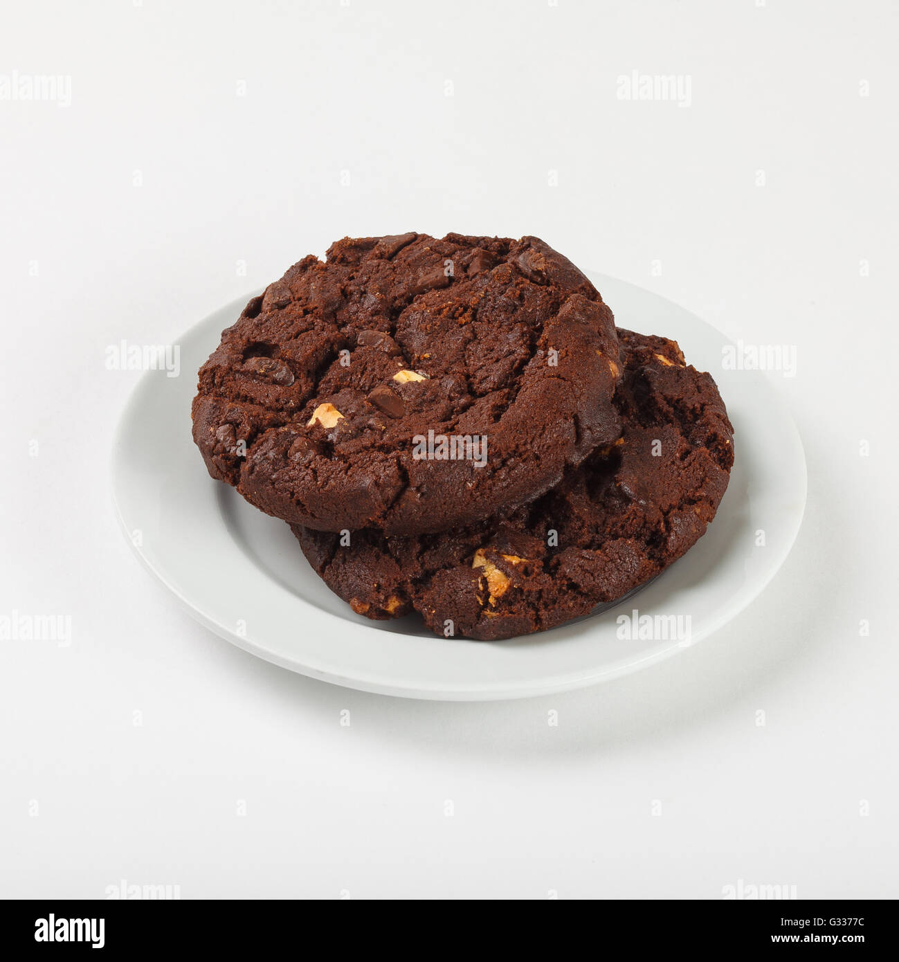 Delicious biscuit cookies with chocolate chips on the plate on white background. Close up side view. Stock Photo