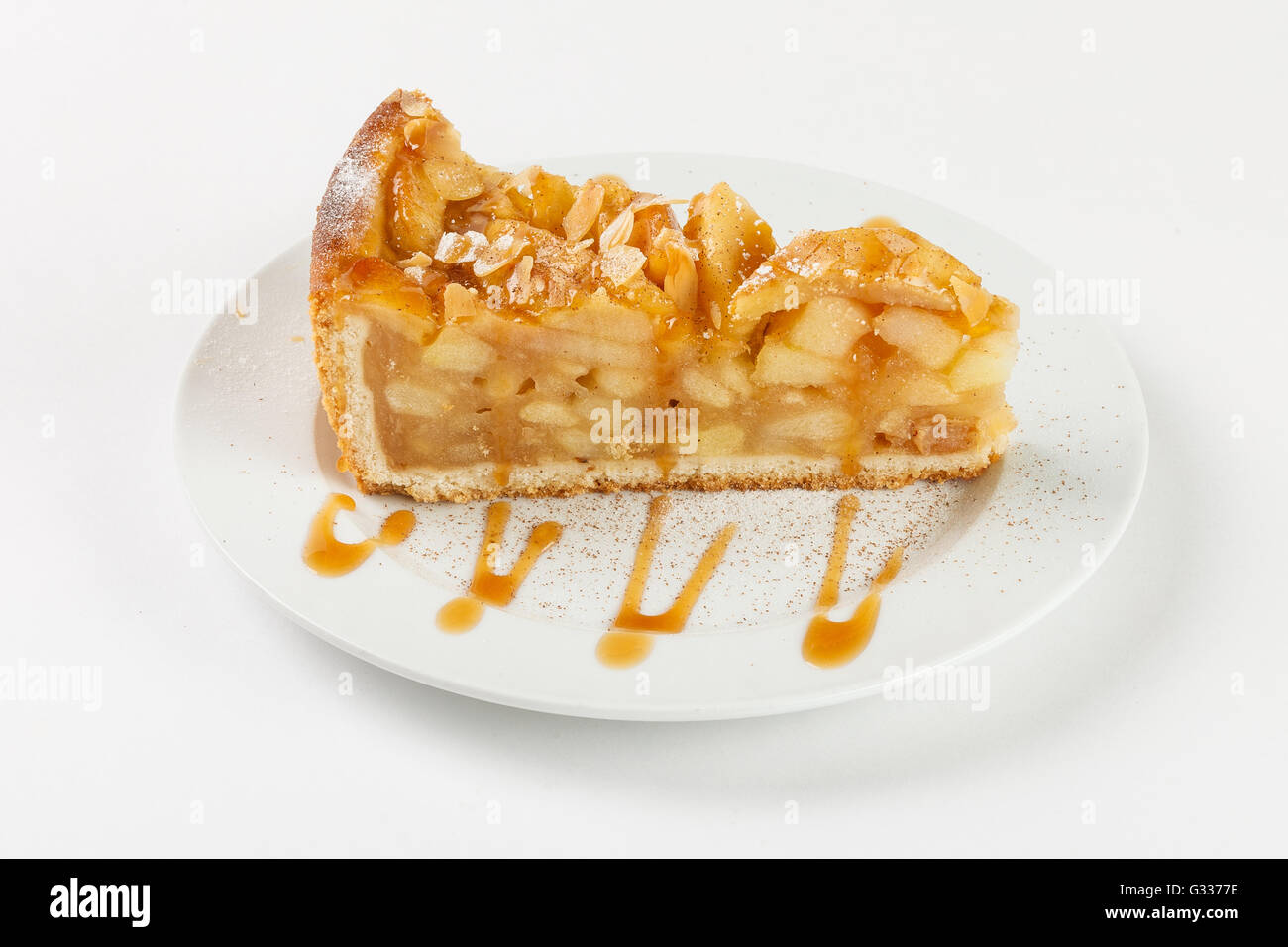 Delicious apple pie charlotte with caramel on the plate on white background. Close up side view. Stock Photo