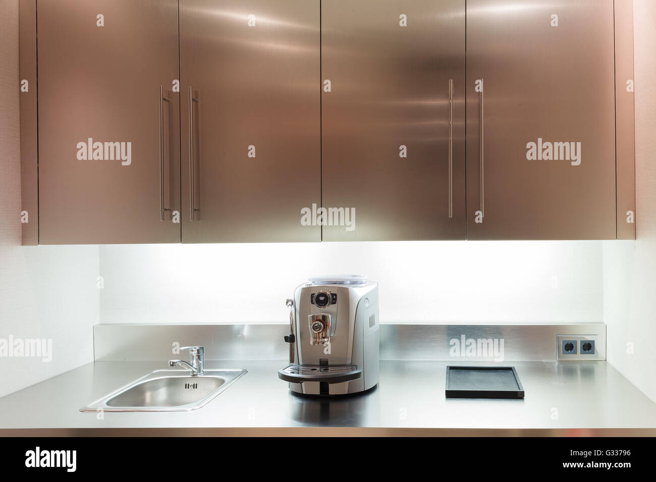 Office kitchen interior with sink, fridge and coffee machine Stock