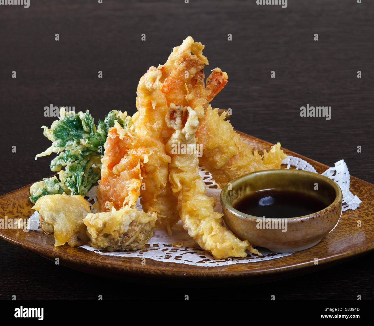 Tempura shrimps (deep fried shrimps) with soy sauce. Decorating dish of Japanese and Asian cuisine. Close up side view. Stock Photo
