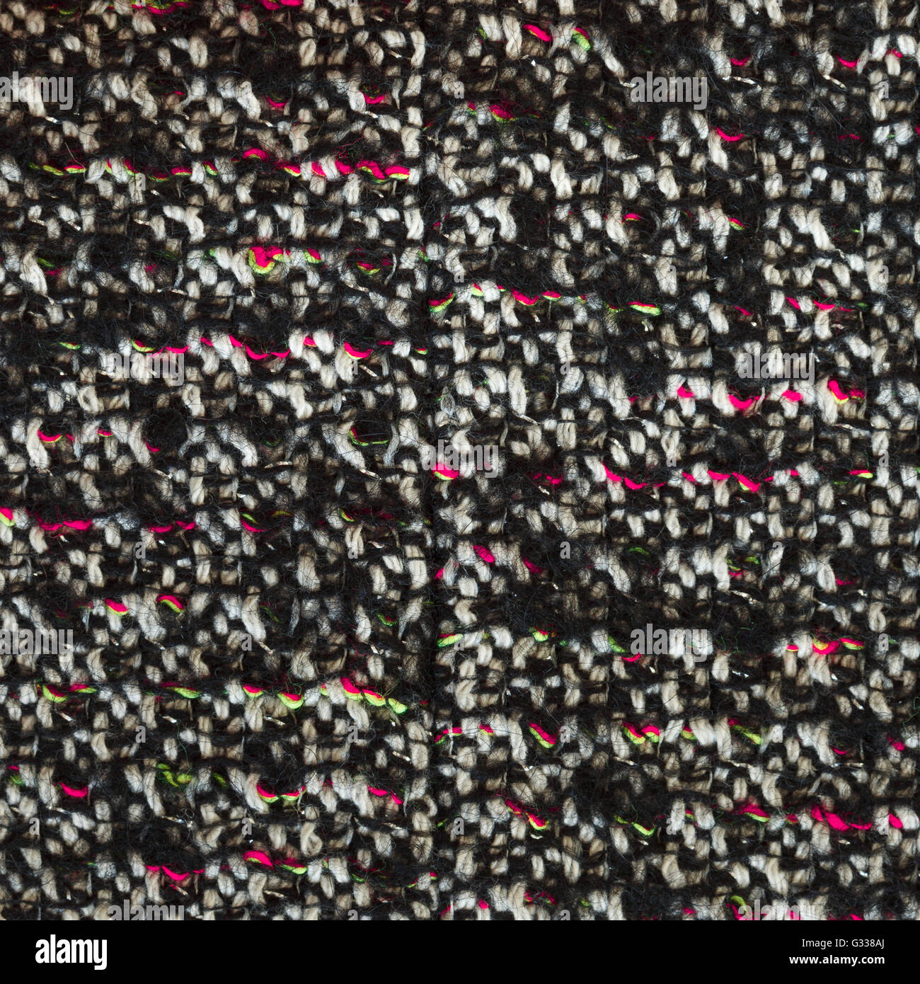 Bottle green woven woolen fabric texture. Black, white, red, magenta complicated melange. Close up fragment of the top view. Stock Photo