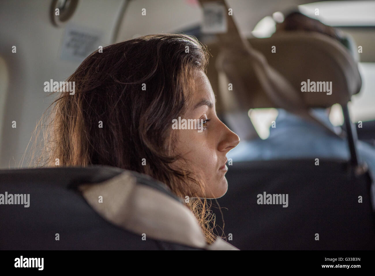 Young woman sitting behind the pilot in a light aircraft flying into the Okavango Delta Stock Photo