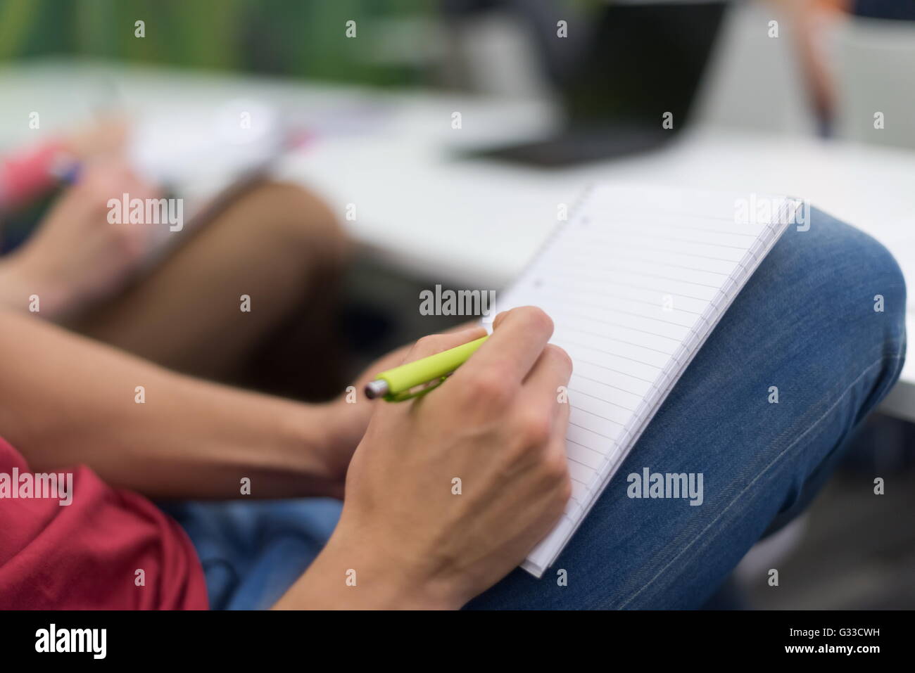 male student taking notes in classroom. business education concept ...