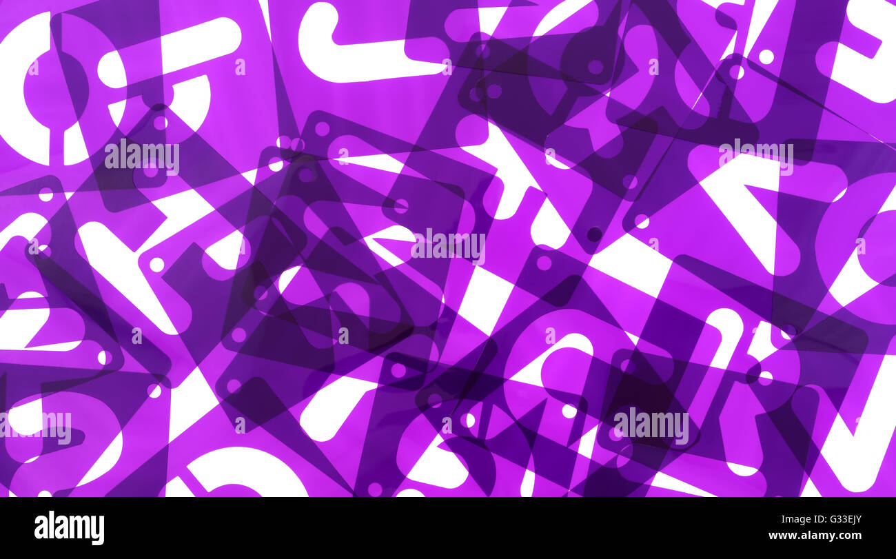 Close view of purple alphabet poster board stencils in a mess on a white background. Stock Photo