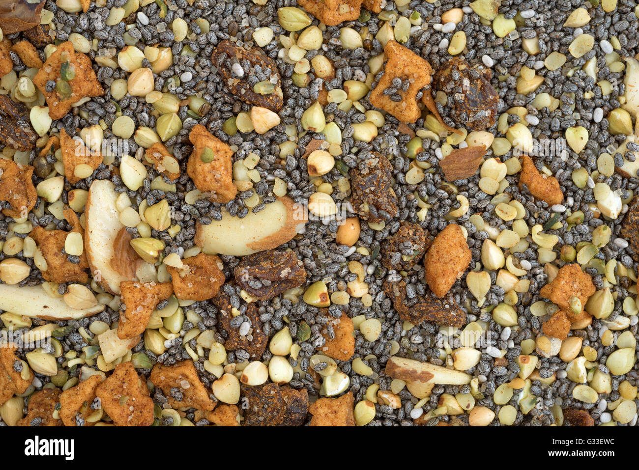 Very close view of dry breakfast cereal consisting of chia seeds, nuts, and dried fruit. Stock Photo