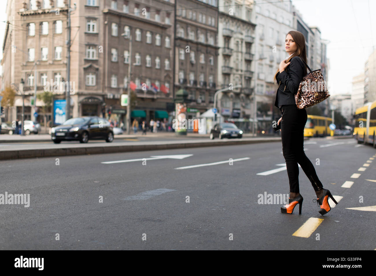 Young woman crossing the street in the city Stock Photo - Alamy