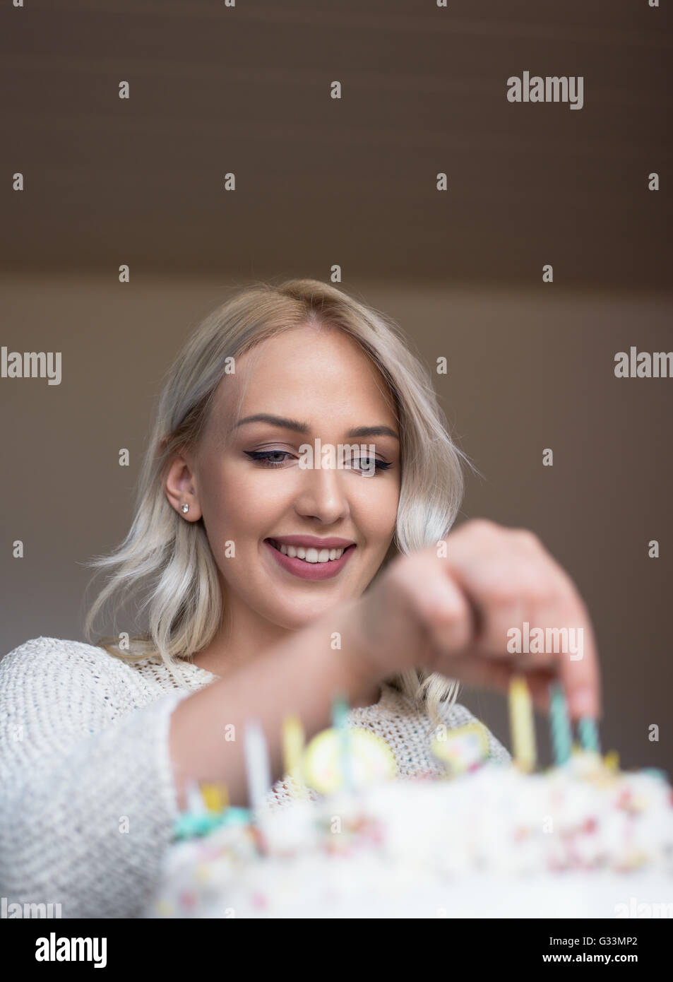 Portrait of a young beautiful blond girl holding plate with birthday ...