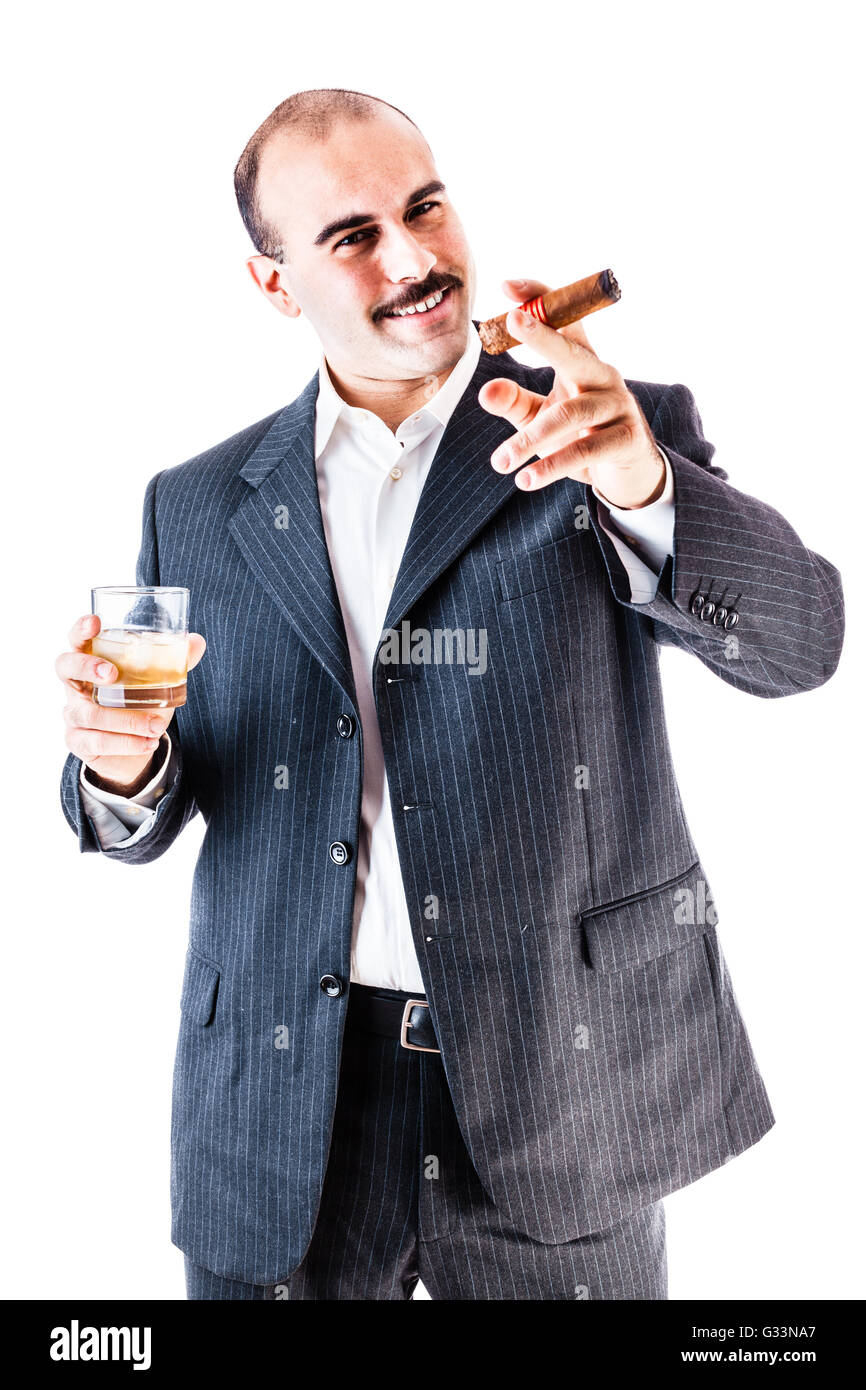 portrait of a classy businessman toasting with a glass of whiskey and smoking a cigar isolated over a white background Stock Photo