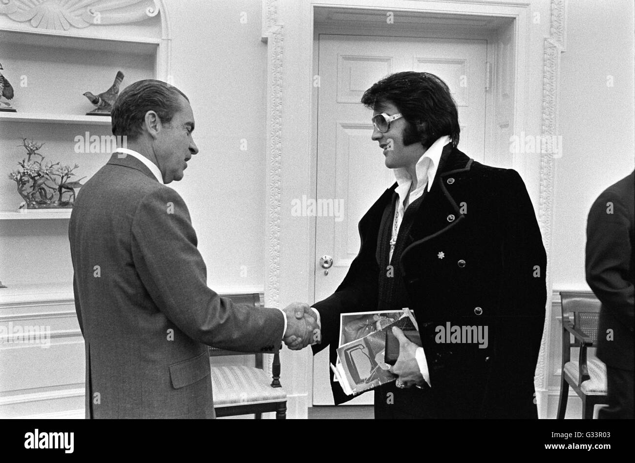 Elvis Presley greets U.S President Richard M. Nixon in the Oval Office at the White House December 21, 1970 in Washington, DC. The meeting was initiated by Presley, who wrote Nixon a six-page letter requesting a visit with the President and suggesting that he be made a 'Federal Agent-at-Large' in the Bureau of Narcotics and Dangerous Drugs. Stock Photo