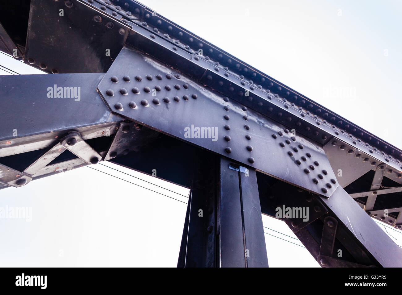 a strong riveted steel beams structure of a railway bridge Stock Photo