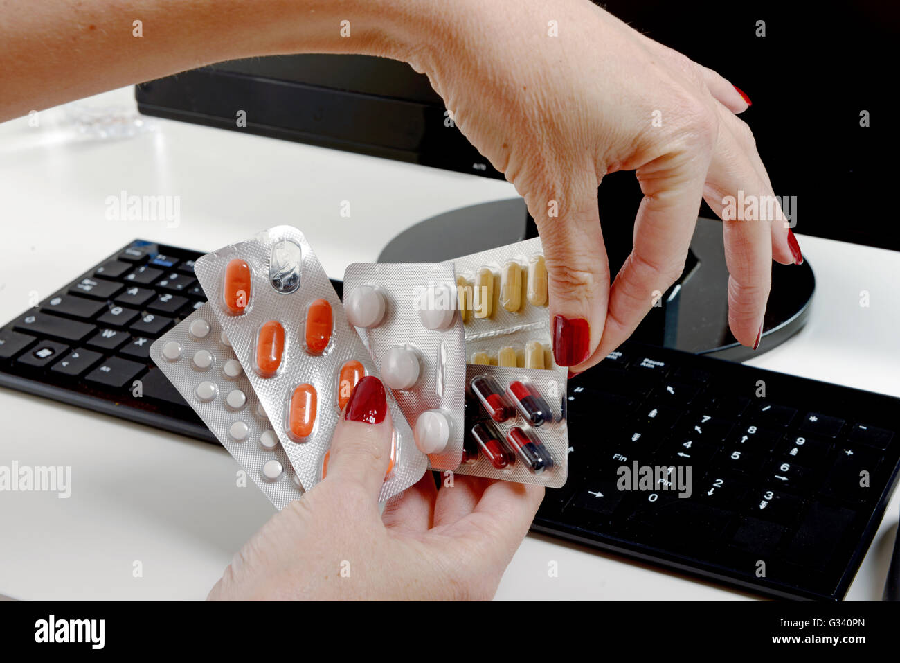 a businesswoman taking pills at workplace Stock Photo