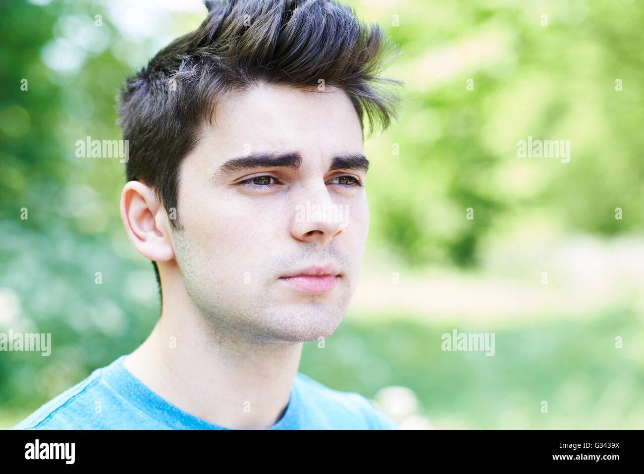 Outdoor Head And Shoulders Portrait Of Serious Young Man Stock Photo