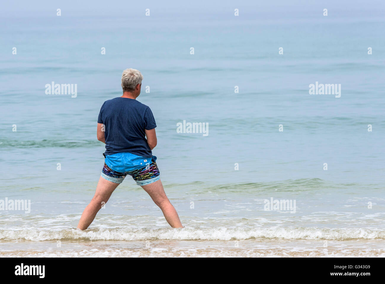 A man with a strange stance at Fistral Beach in Newquay, Cornwall. Stock Photo