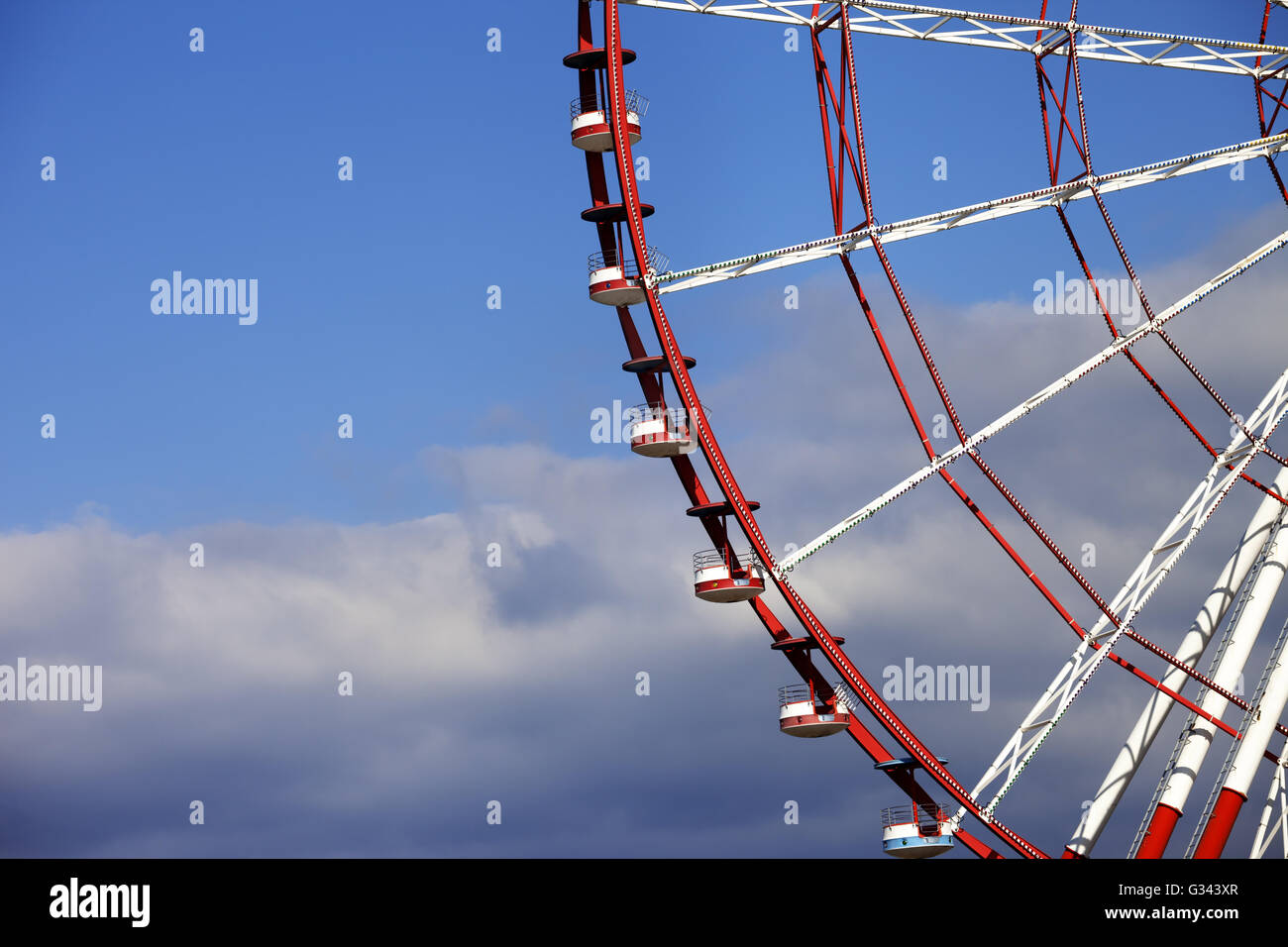 Part of ferris wheel and blue sky with clouds Stock Photo - Alamy