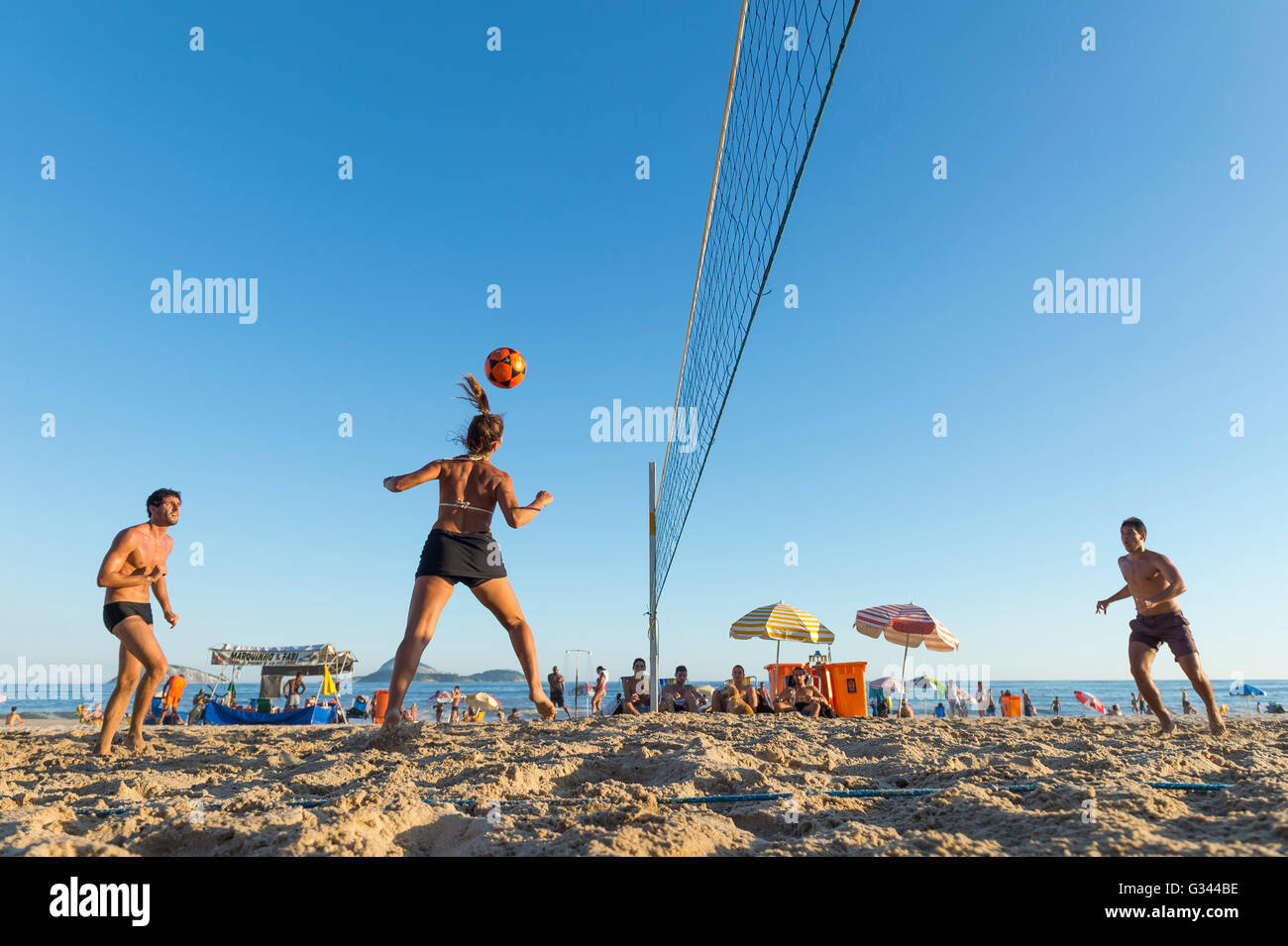 RIO DE JANEIRO - MARCH 17, 2016: Young Brazilian men and women play futevolei (footvolley), combining football and volleyball. Stock Photo