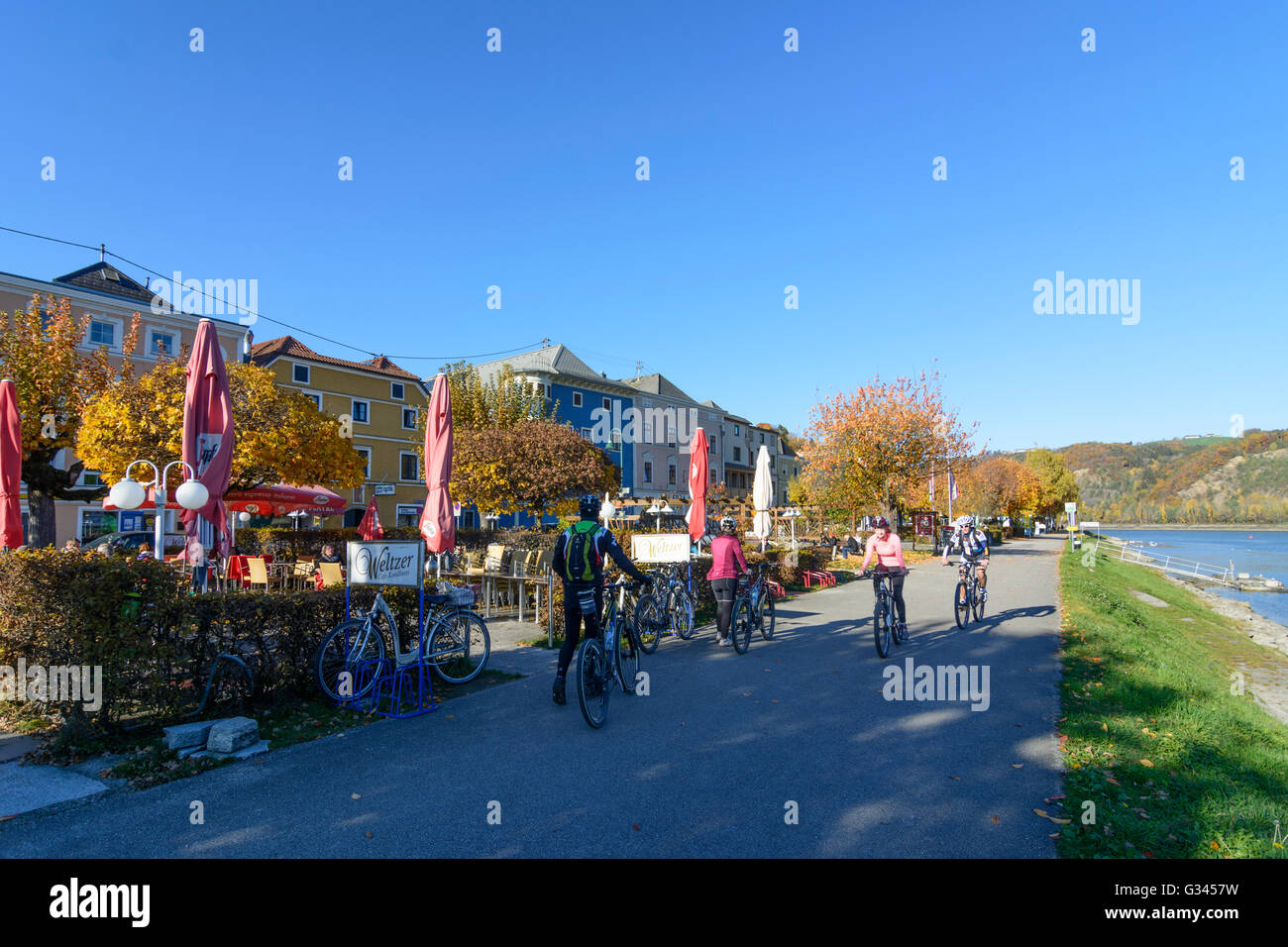 Cafe on the promenade on the Danube and cyclists, Austria, Oberösterreich, Upper Austria, , Aschach an der Donau Stock Photo