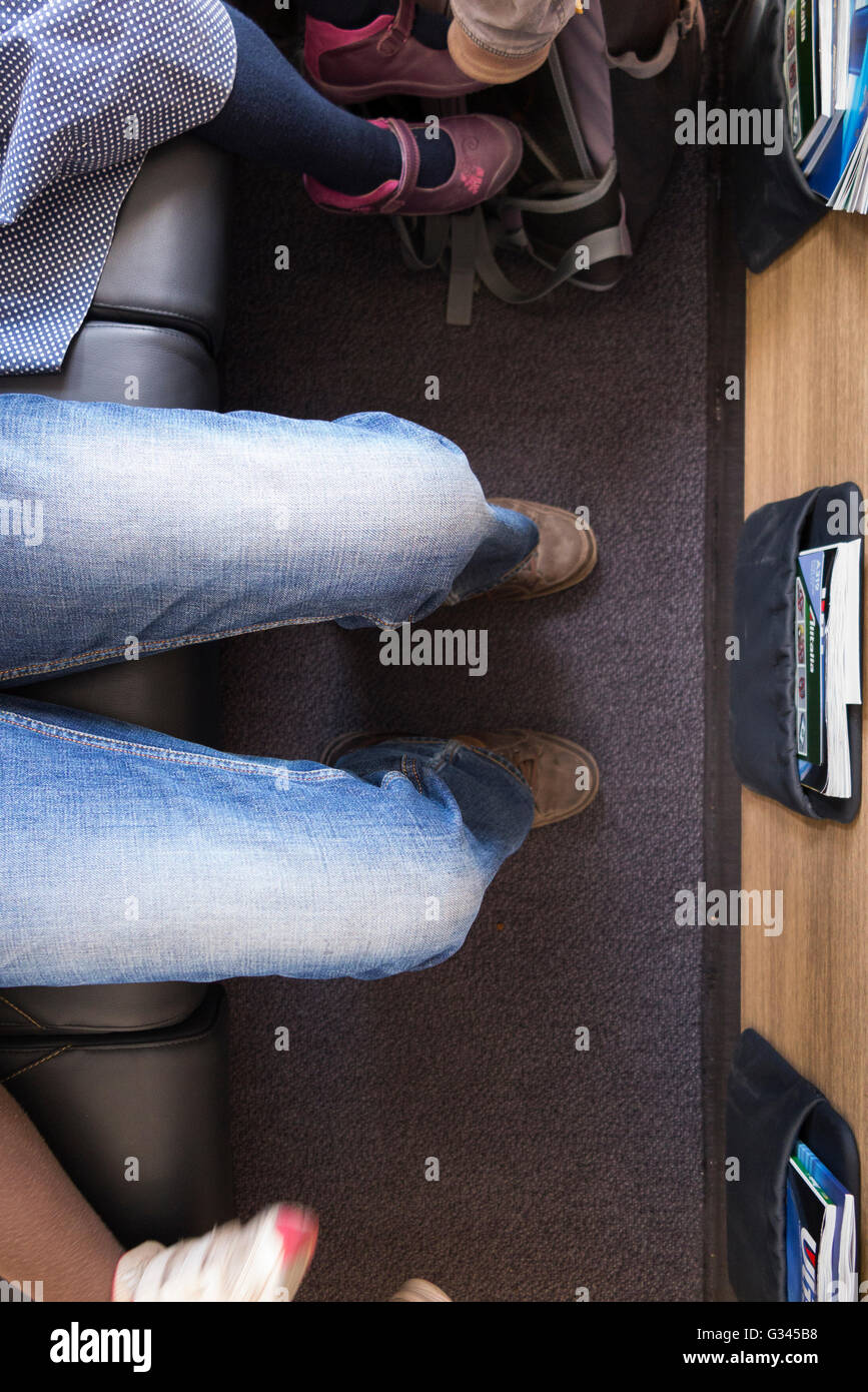Passenger's legs wearing denim jeans shown while sitting in an Airbus