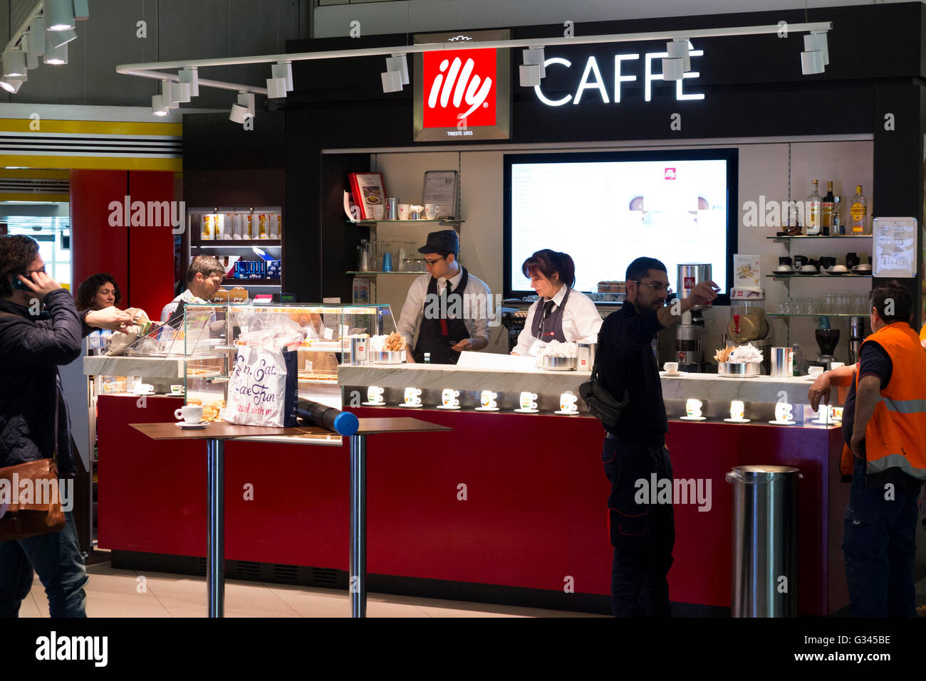 Illy brand Caffe / cafe coffee shop which serves / is serving drinks and snacks to passengers at Milan airport, Italy. Stock Photo