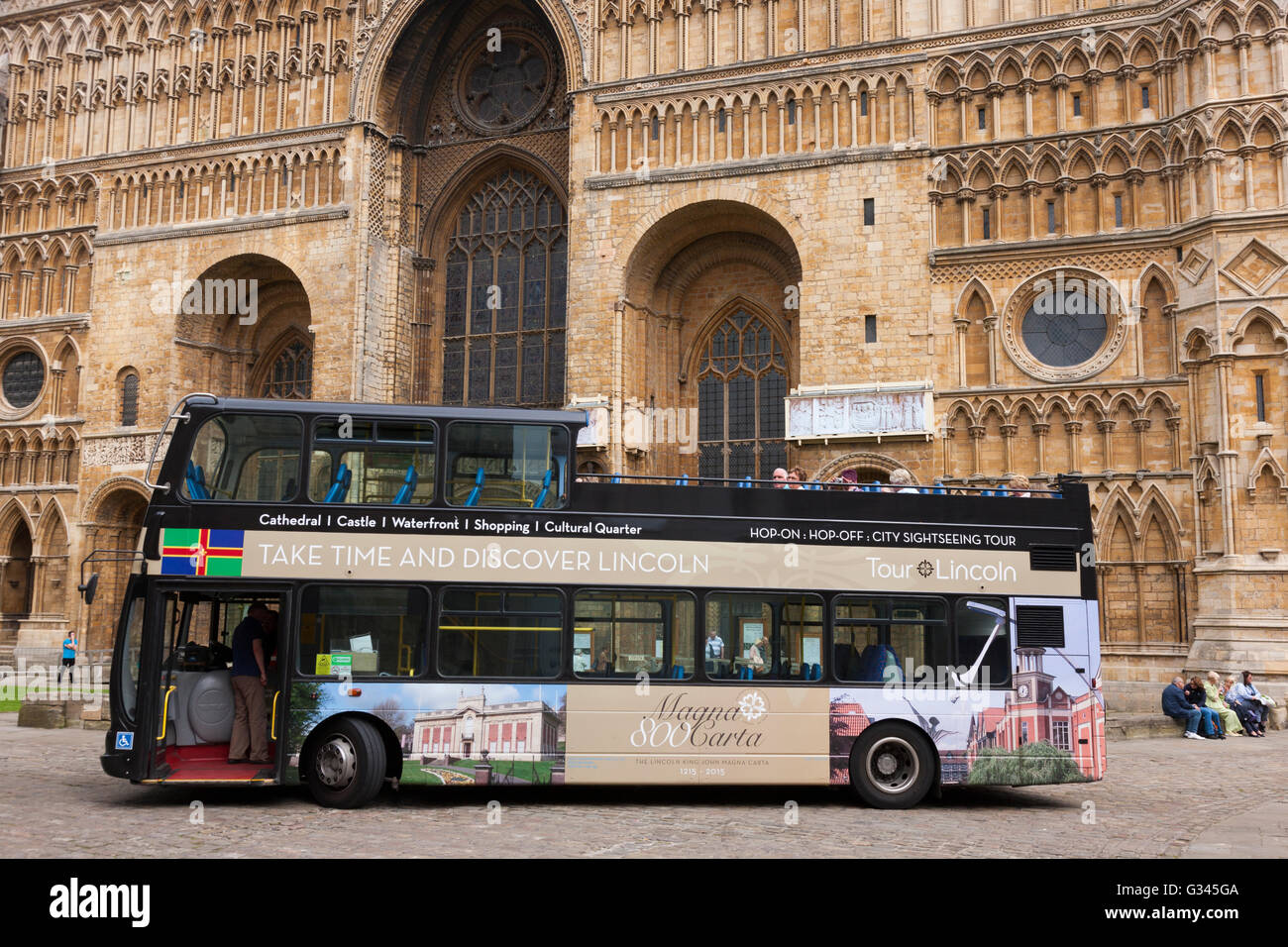 ' Tour Lincoln ' open top / topped tourist bus outside Lincoln Cathedral, Lincoln. UK Stock