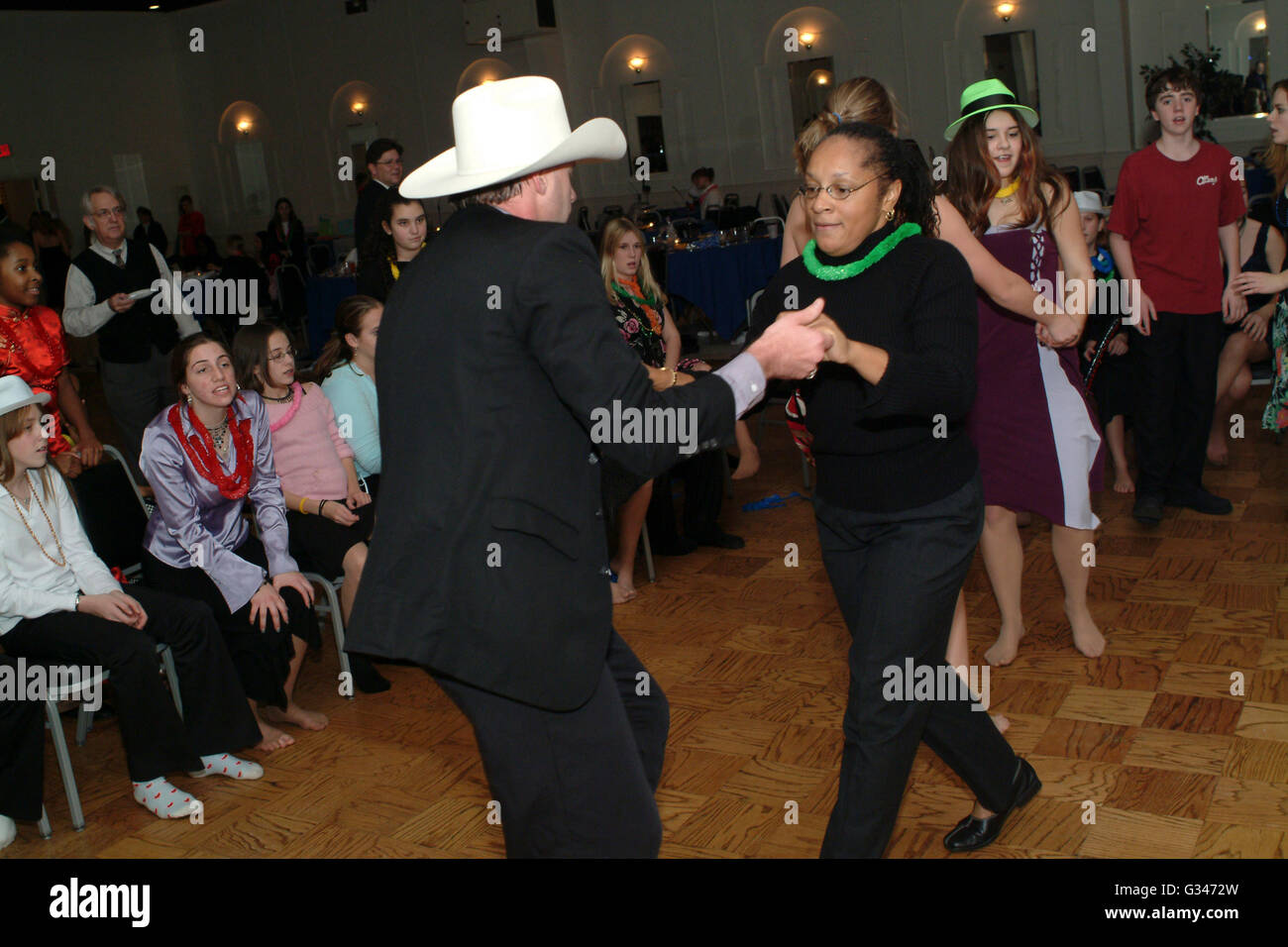 Man with cowboy hat dances with African American woman at dance in