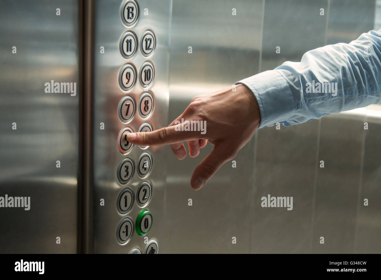 Pressing the button in the elevator Stock Photo