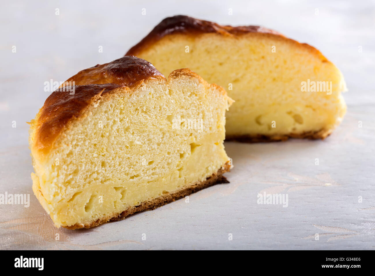 Cut in half of fresh homemade Romanian cheese pie on table Stock Photo