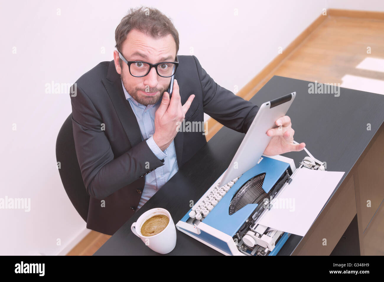 Old fashioned worker confused with new technology devices Stock Photo