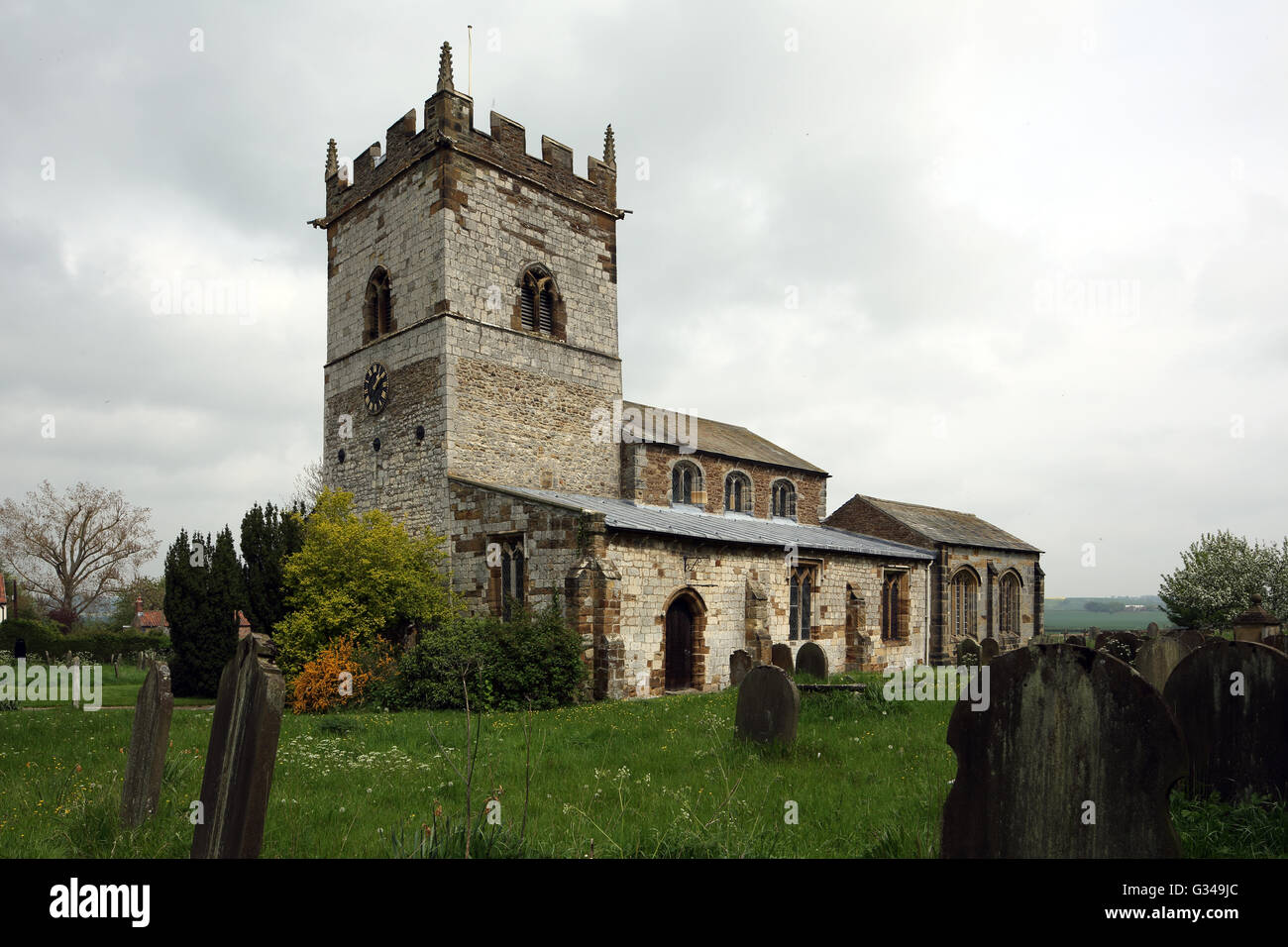 St. Helen and the Holy Cross church, Sheriff Hutton, North Yorkshire, England, UK, with part of the graveyard in the foreground. Stock Photo