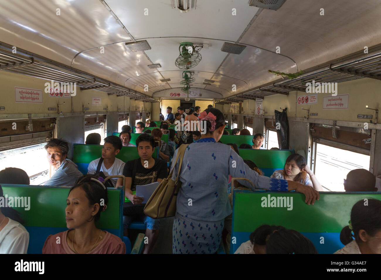 Burmese passengers in ordinary class passenger carriage of an old British train in Myanmar / Burma Stock Photo