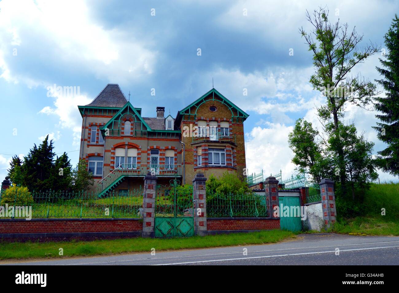 Former magnificent house with arches, wall in grey and red stones. Stock Photo