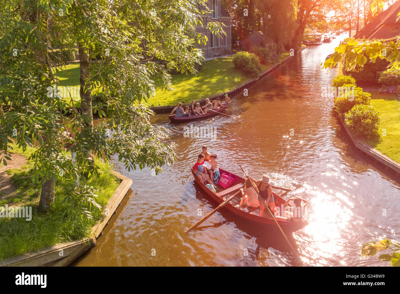 Giethoorn, Netherlands. Children punting and rowing traditional boats in the Dorpsgracht or Village Canal of Giethoorn Stock Photo