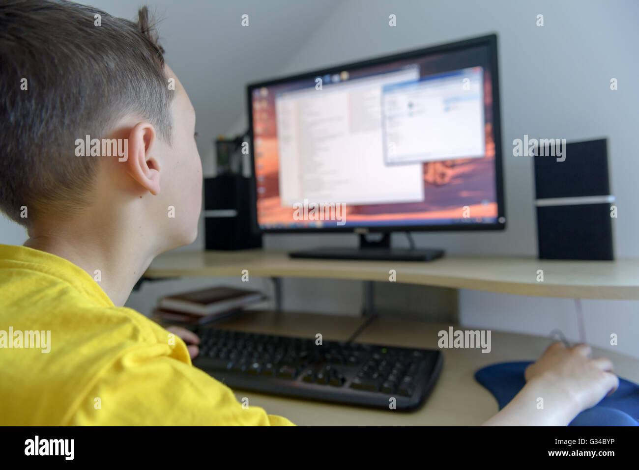 Boy working on computer in his room Stock Photo