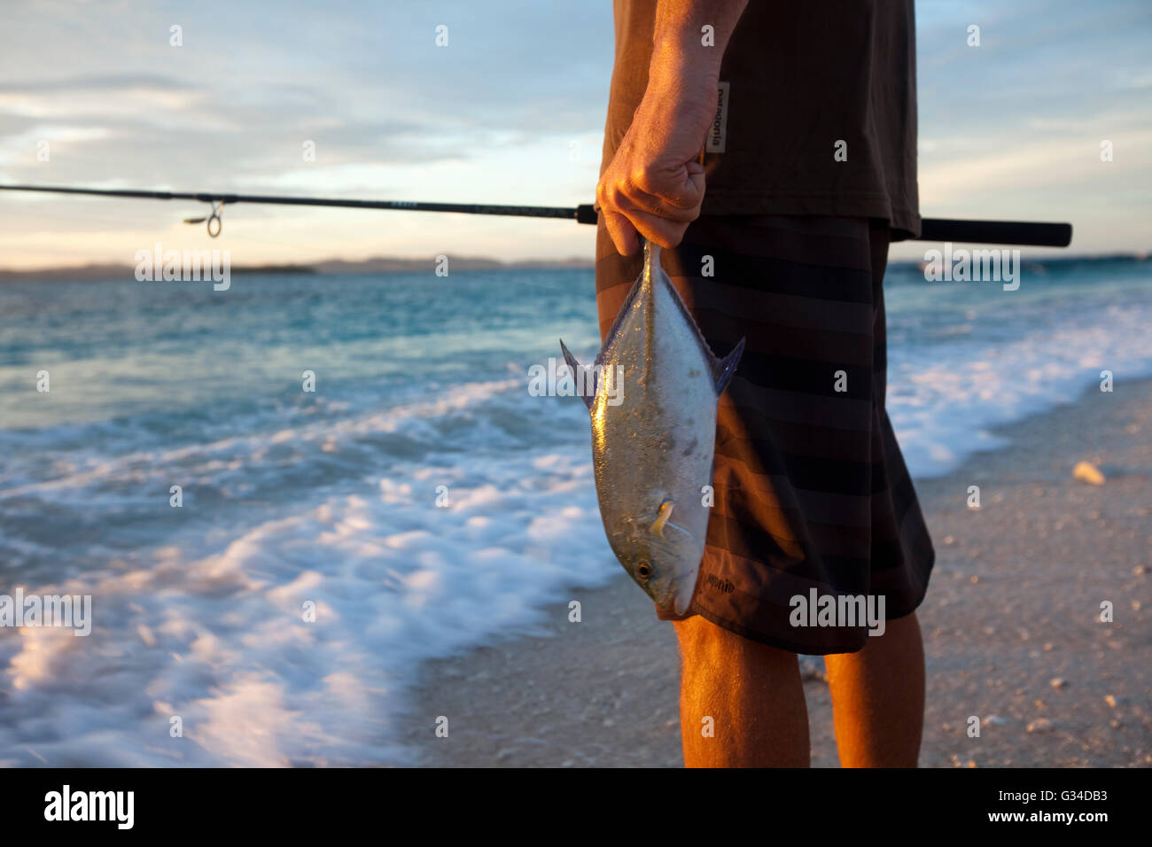 Brad Osborn fishing for Papio at sunrise on the beach at Namotu Island, Fiji Stock Photo