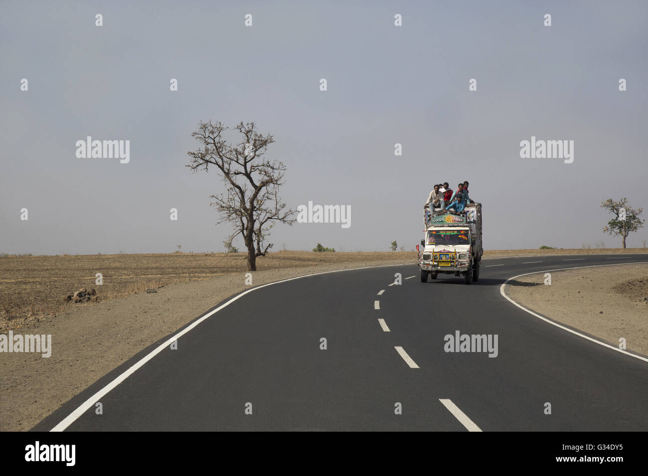 People traveling in a jeep on the Highway, Baroda, Gujrat, India Stock Photo