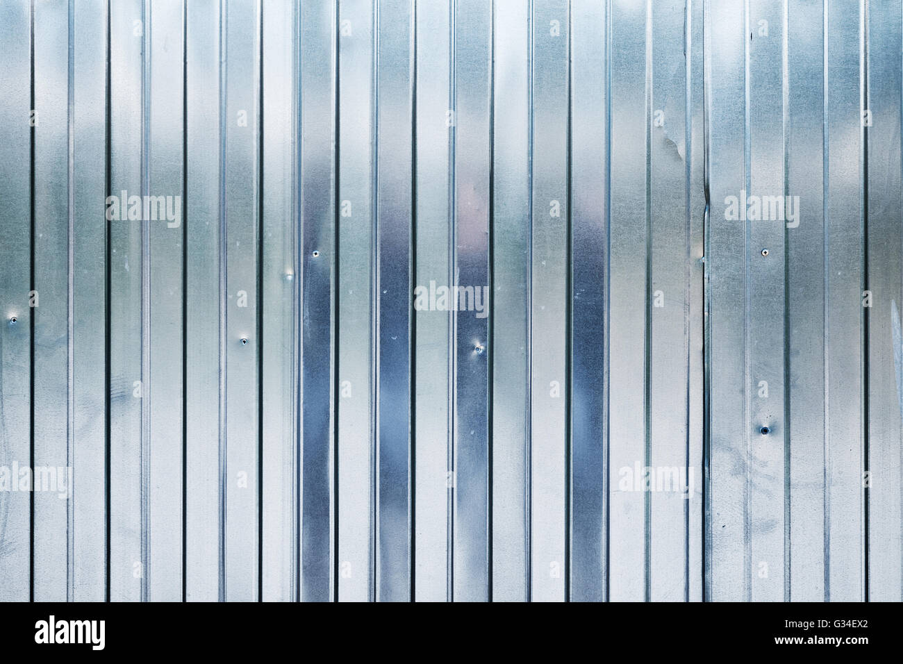 New shining corrugated metal fence, industrial wall background photo texture Stock Photo