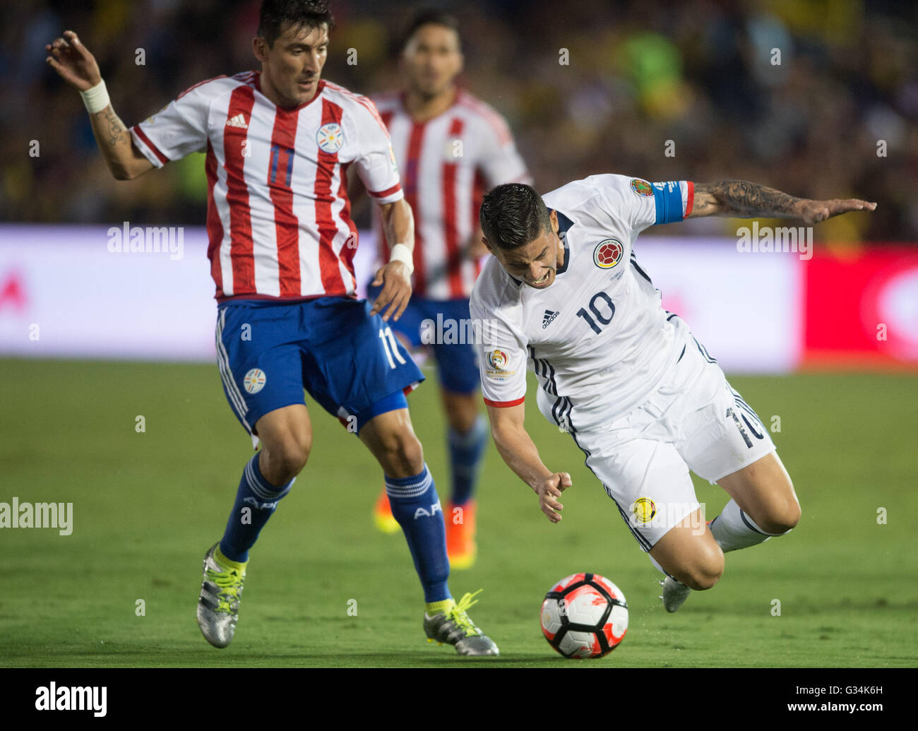 Pasadena, USA. 7th June, 2016. Colombia's James Rodriguez (R) falls during the Copa America Centenario Group A match between Colombia and Paraguay at Rose Bowl Stadium in Pasadena, California, the United States, June 7, 2016. © Yang Lei/Xinhua/Alamy Live News Stock Photo