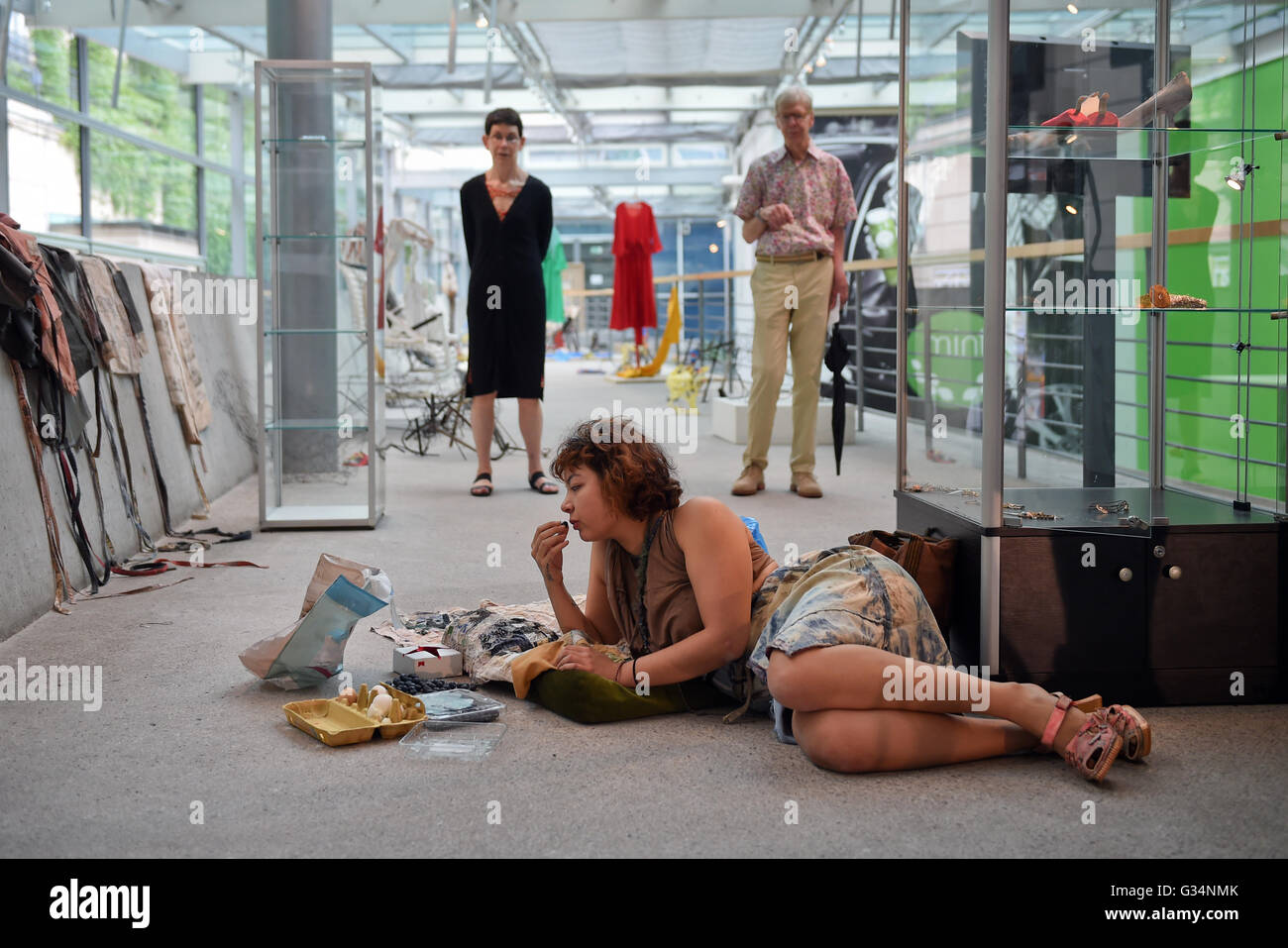 A live installation contains a woman lying on the ground and eating at the 9th Berlin Biennale, Germany, 2 June 2016. The festival for modern art takes place from 04.06.-18.09.2016. Photo: Britta Pedersen/dpa Stock Photo