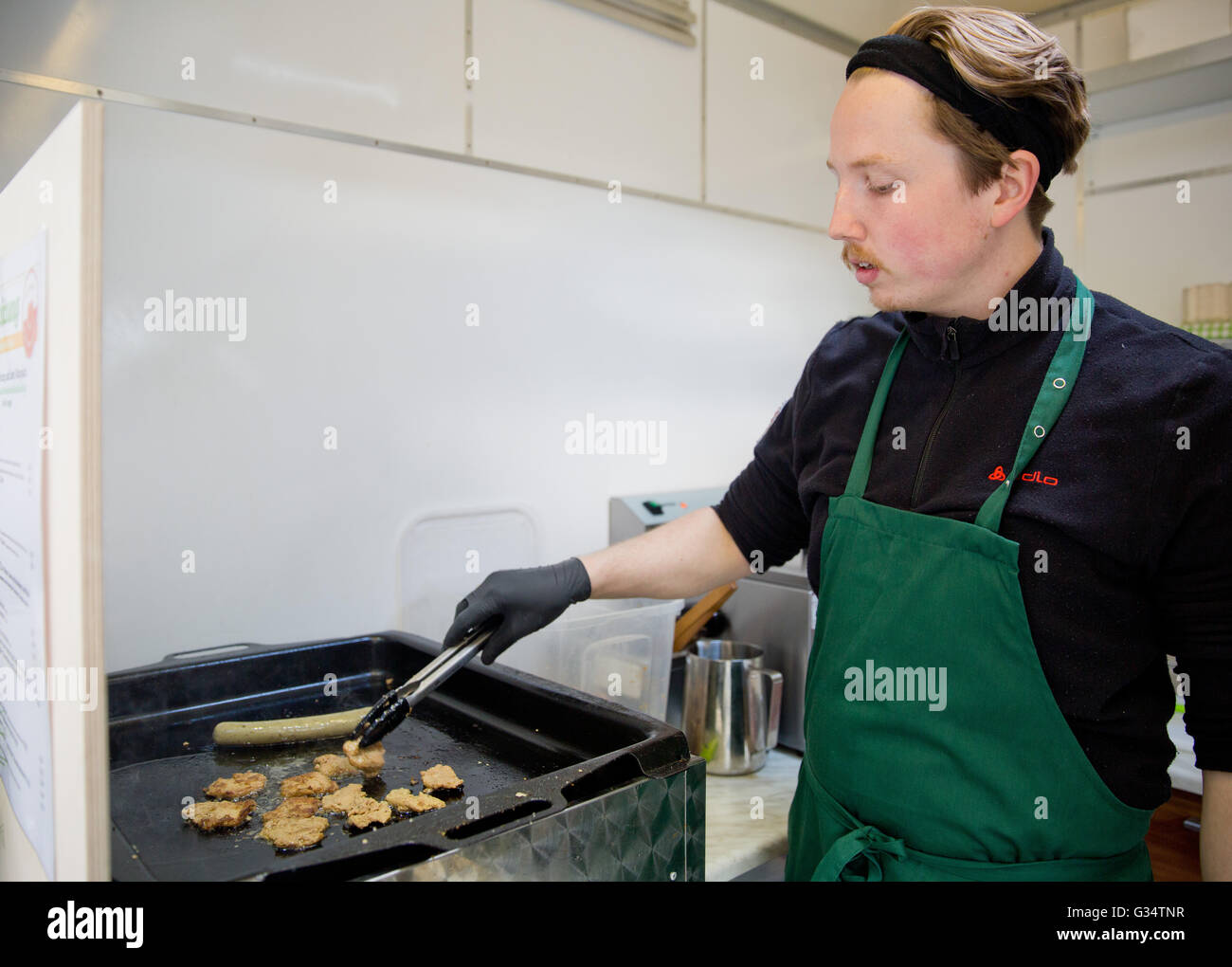 Stefan Vinzelberg prepares soy patties for a burger in his vegan fast food stall in Bamberg, Germany, 29 April 2016. The 29-year-old man has been a vegetarian for 14 years and a vegan for nine years. He has opened his own stall Vegbereitung in Bamburg in the spring. Photo: DANIEL KARMANN/dpa Stock Photo