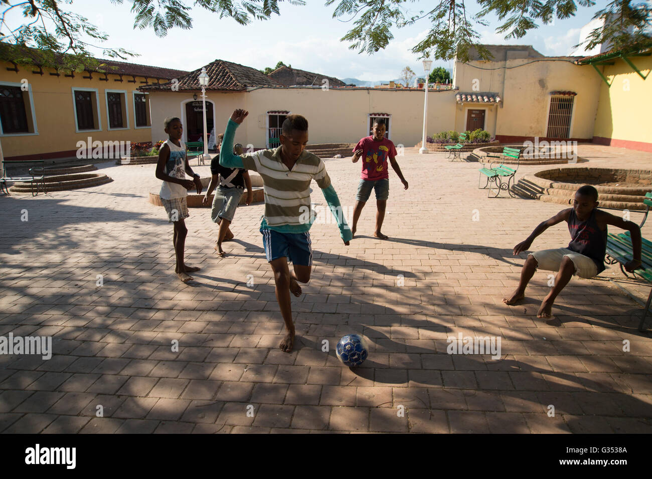 Children playing football barefoot in the streets of Trinidad Cuba