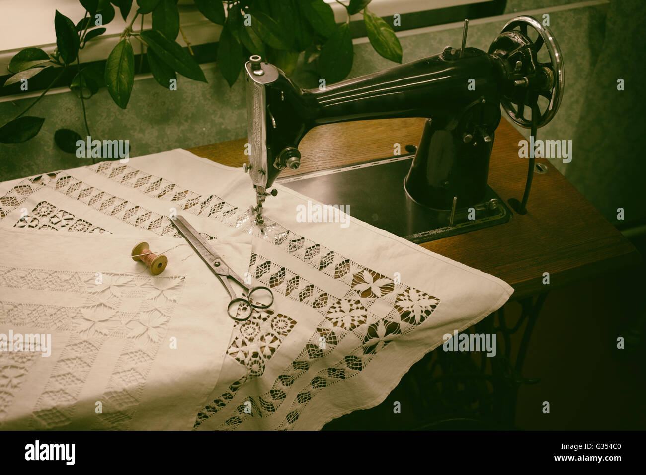 Retro sewing machine in the interior with accessories Stock Photo