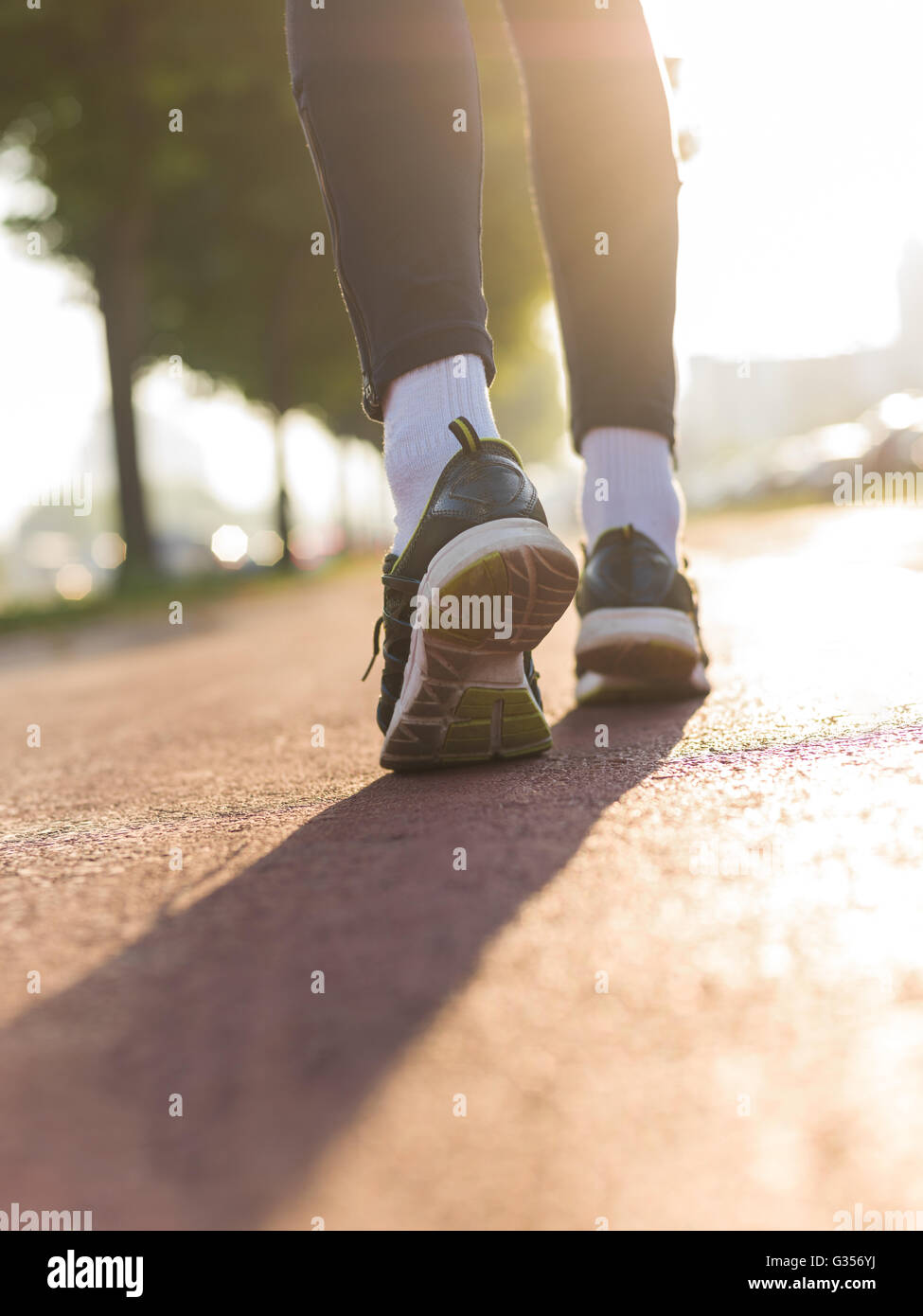 Running shoes, feet and legs close up of runner jogging in action and