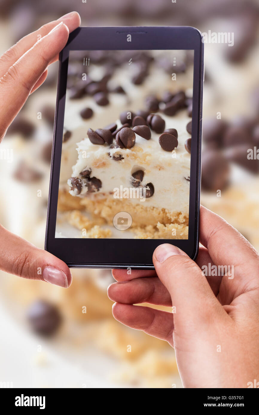 a woman using a smart phone to take a photo of a delicious cake Stock ...