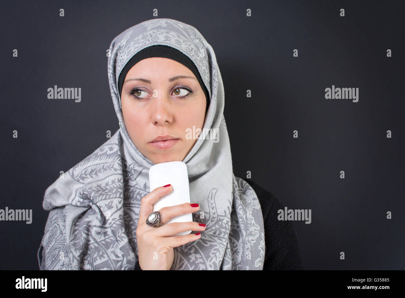 Beautiful muslim woman in hijab holding a mobile phone Stock Photo - Alamy
