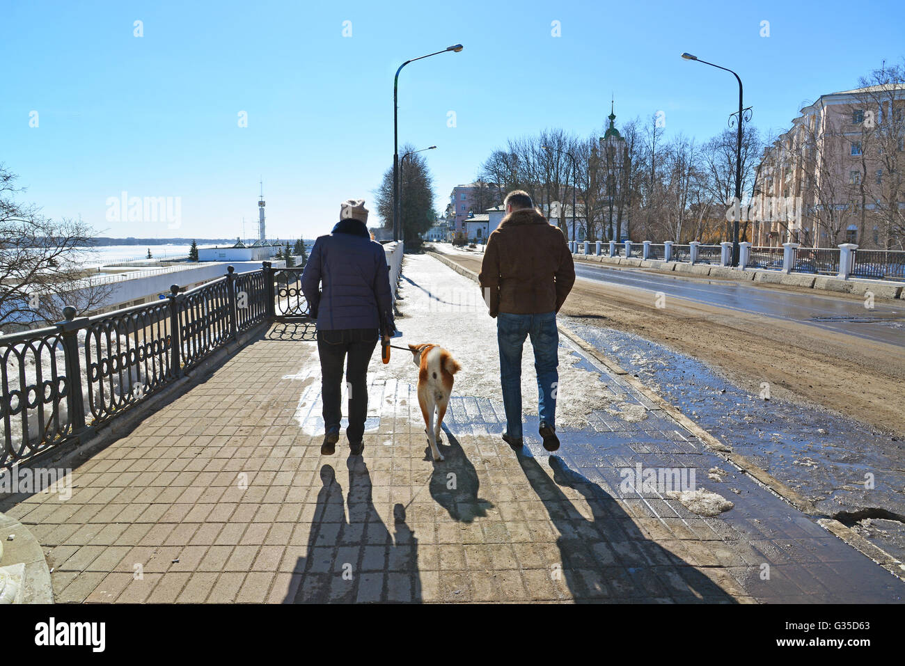 Man and woman walking with dog in the town Stock Photo - Alamy