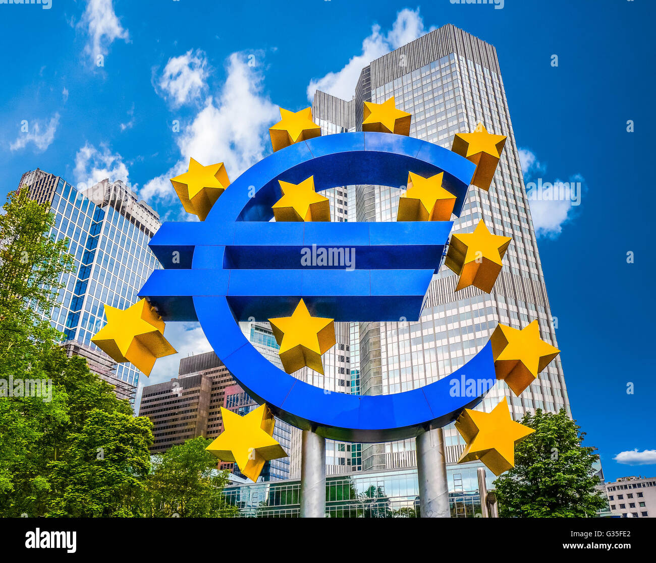 Euro sign at European Central Bank headquarters in Frankfurt, Germany with dark dramatic clouds symbolizing a financial crisis Stock Photo