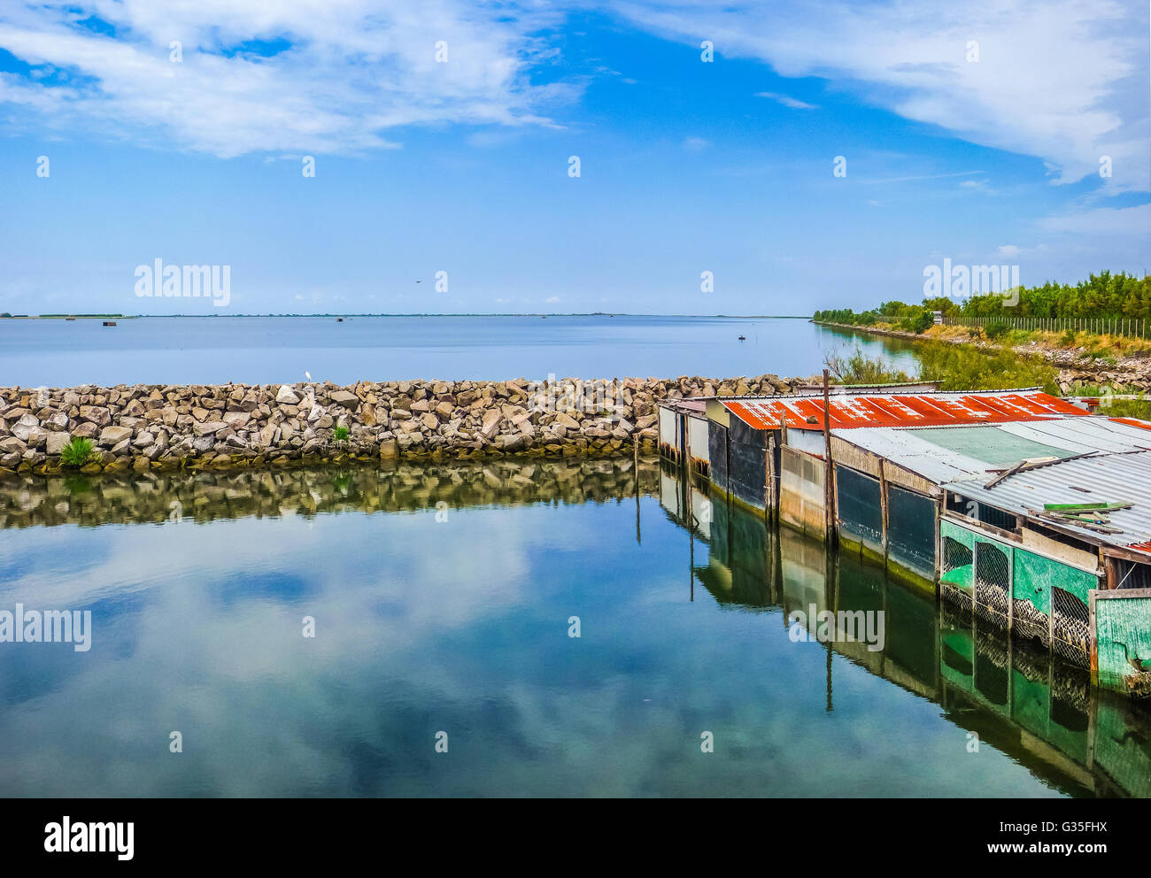 Beautiful view of tranquil seascape with colorful shanties in the Delta del Po national park region on a sunny day, Venetian Lagoon, Italy Stock Photo
