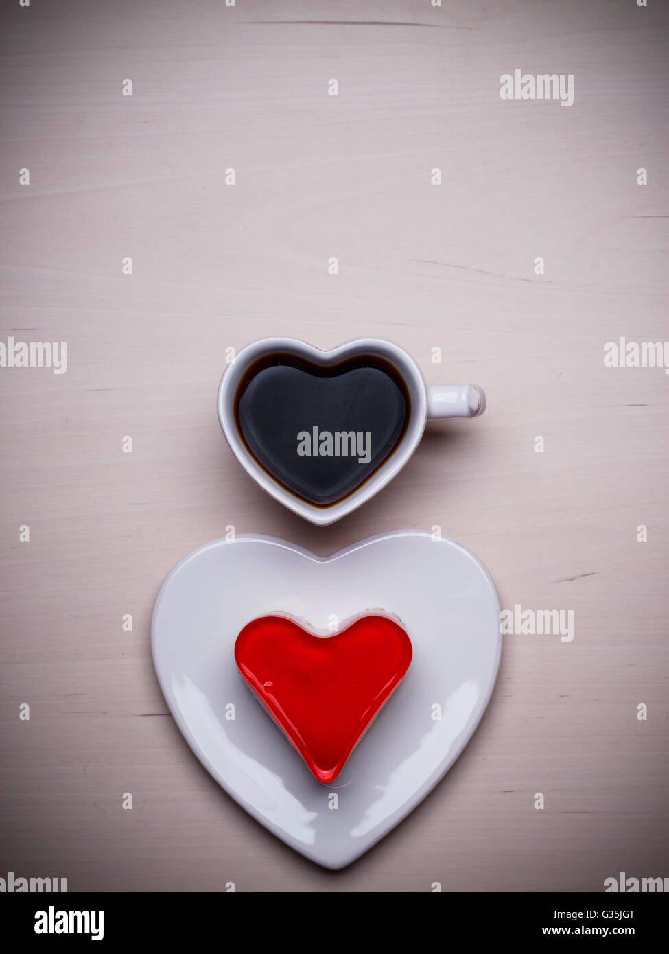 Heart shaped coffee cup and jelly cake on wooden surface, top view copy space for text Stock Photo